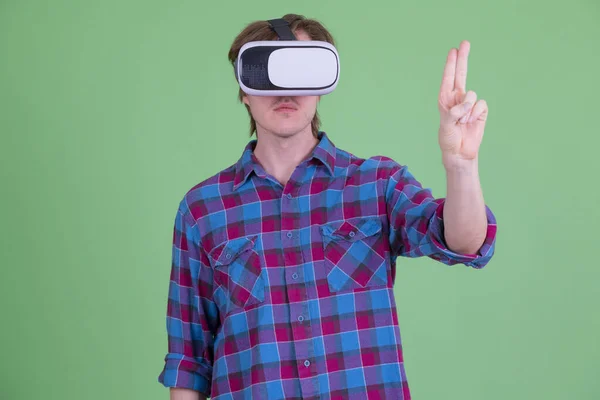 Homem jovem hipster tocando em algo enquanto usa fone de ouvido de realidade virtual — Fotografia de Stock