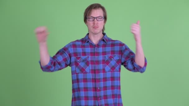 Confused young hipster man choosing between thumbs up and thumbs down — Stock Video