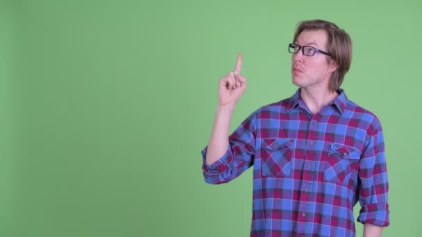 Jonge knappe hipster man denken terwijl omhoog wijzen — Stockvideo