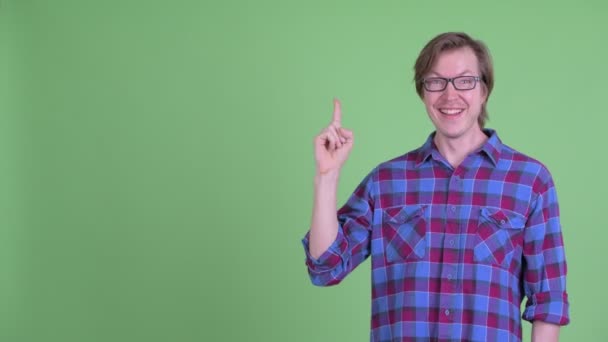 Feliz jovem bonito hipster homem pensando enquanto apontando para cima — Vídeo de Stock