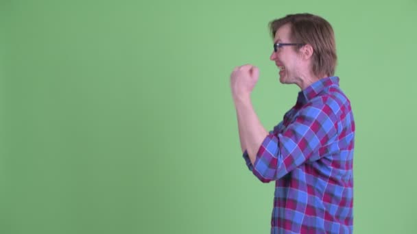 Profile view of happy young hipster man with fists raised — Stock Video