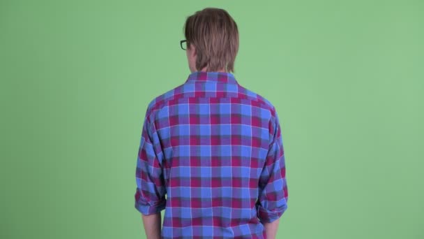 Rear view of young hipster man thinking while looking around — Stock Video