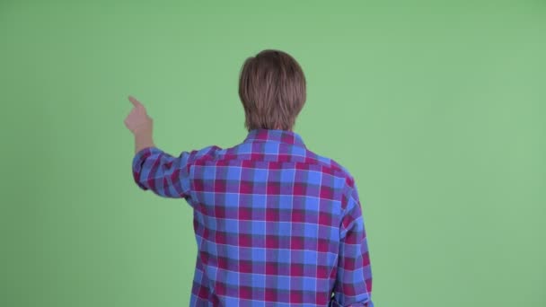 Вид сзади на молодого хипстера, указывающего пальцем и трогающего что-то. — стоковое видео