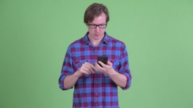 Mutlu genç, yakışıklı hippi telefonu kullanıyor ve iyi haberler alıyor.
