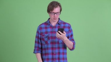 Stresli genç hipster adam telefon kullanarak ve kötü haber alıyorum