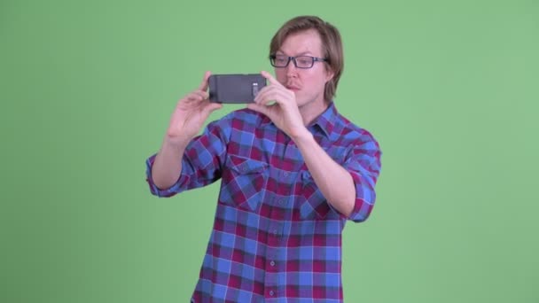 Giovane bello hipster uomo scattare foto con il telefono — Video Stock