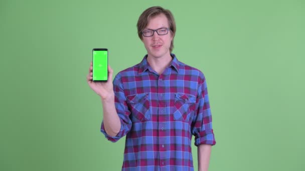 Gelukkig jong knap hipster man tonen telefoon — Stockvideo
