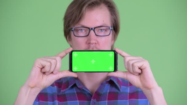 Gezicht van de jonge knappe hipster man met telefoon — Stockvideo