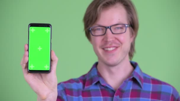 Gezicht van Happy Young knappe hipster man toont telefoon — Stockvideo