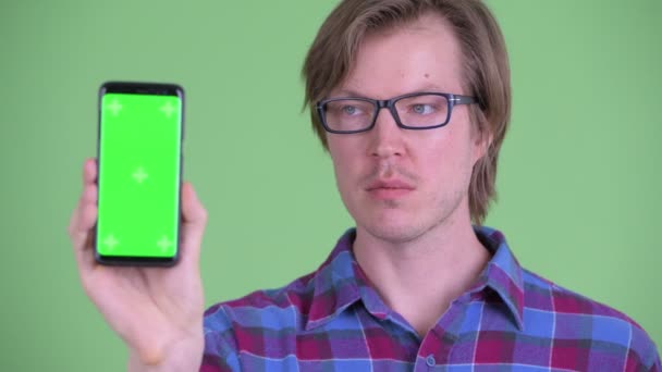 Gesicht des jungen hübschen Hipster-Mannes zeigt Handy — Stockvideo