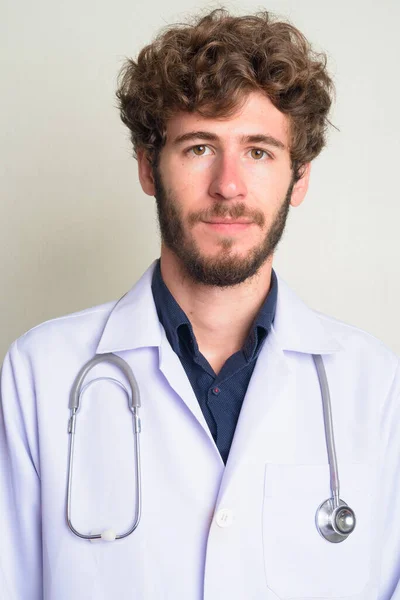 Rosto de jovem barbudo homem médico com cabelo encaracolado — Fotografia de Stock