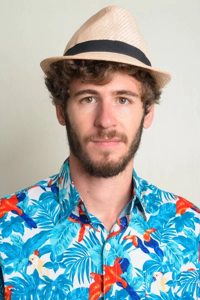 Rosto do jovem turista barbudo com cabelo encaracolado usando chapéu — Fotografia de Stock