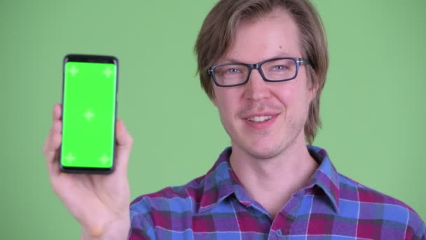 Gezicht van Happy Young knappe hipster man toont telefoon — Stockvideo