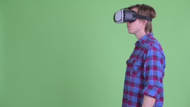 Profiel weergave van jonge hipster man met behulp van virtual reality headset — Stockvideo