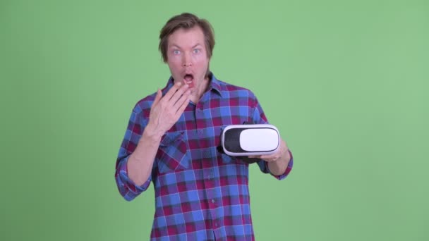 Jonge hipster man met virtual reality headset en kijken geschokt — Stockvideo