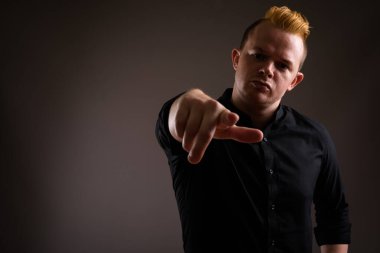 Gri ba karşı Mohawk saç modeli ve sarı saçlı işadamı