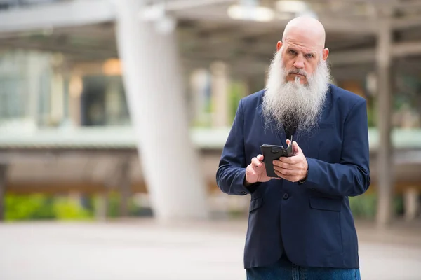 Maturo barbuto calvo uomo d'affari utilizzando il telefono in città all'aperto — Foto Stock