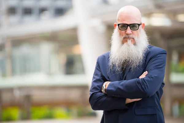 Rijpe baard kale zakenman met zonnebril in de stad buiten — Stockfoto
