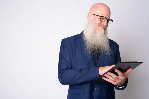 Volwassen kale zakenman met baard in pak lezen op klembord — Stockfoto