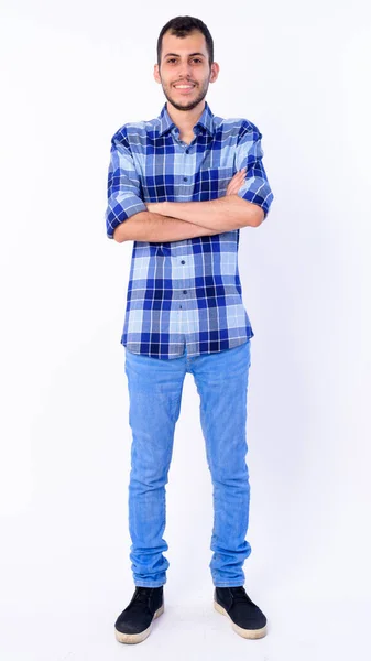 Full body shot of happy young bearded Persian hipster man smiling with arms crossed — Stock Photo, Image