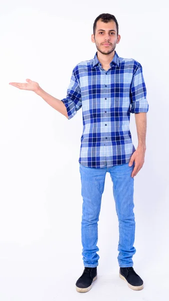 Full body shot of young bearded Persian hipster man showing something — Stock Photo, Image
