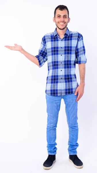 Full body shot of happy young bearded Persian hipster man showing something — Stock Photo, Image