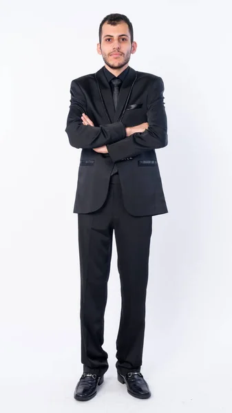 Full body shot of young bearded Persian businessman in suit with arms crossed — Stock Photo, Image