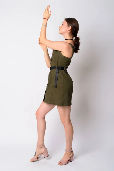 Ganzkörperaufnahme Profil Ansicht der jungen schönen Frau posiert mit erhobenen Armen — Stockfoto