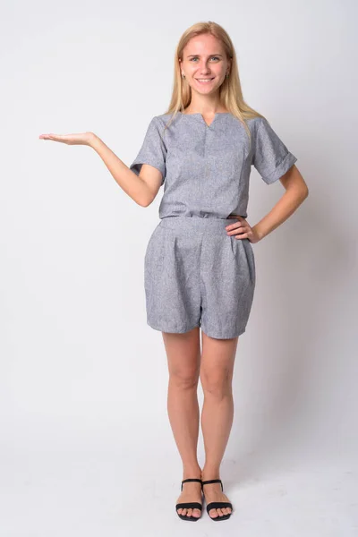 Full body shot of happy young blonde woman showing something — Stock Photo, Image