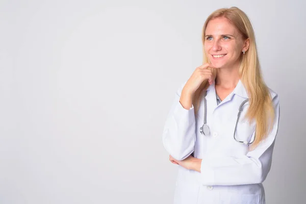 Retrato de feliz jovem loira mulher médico pensando — Fotografia de Stock