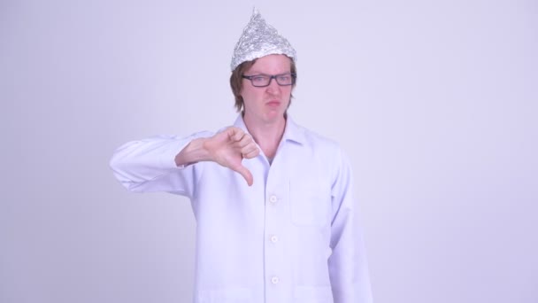 Stressed young man doctor with tinfoil hat giving thumbs down — Stock Video