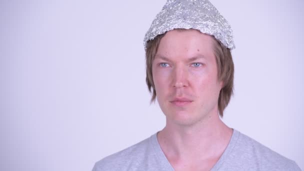 Visage de jeune homme heureux avec chapeau en papier d'aluminium pensant — Video