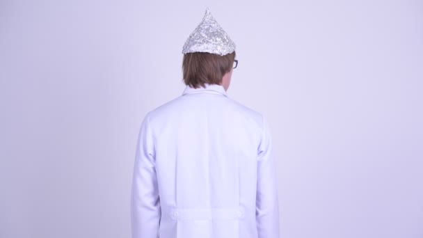 Взгляд на молодого человека-врача в шляпе из фольги как на концепцию теории заговора — стоковое видео