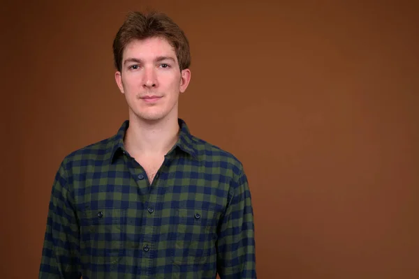 Cara de joven hombre hipster guapo en camisa a cuadros verde — Foto de Stock