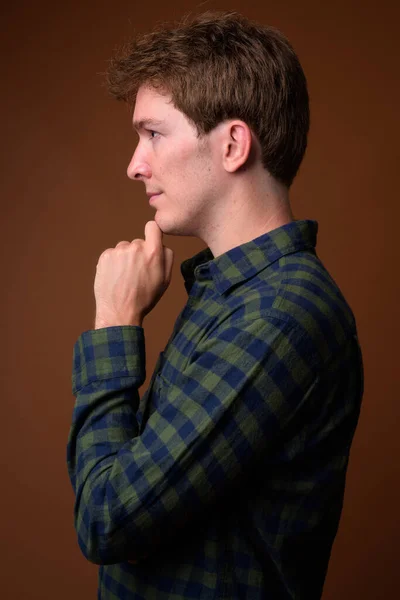 Profile view of young handsome hipster man in green checkered shirt — ストック写真