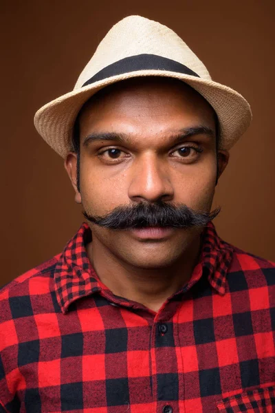 Face of Indian tourist man with mustache wearing hat