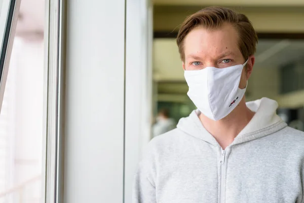 Portrait of young man wearing mask for protection from corona virus outbreak at the gym during quarantine