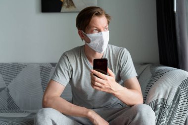 Portrait of young man with mask for protection from corona virus outbreak staying at home during quarantine for covid-19