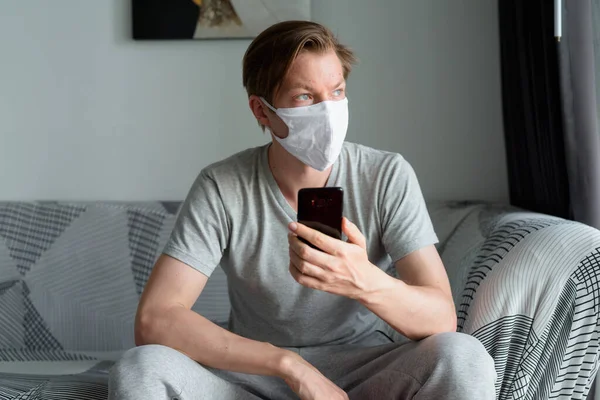 Portrait of young man with mask for protection from corona virus outbreak staying at home during quarantine for covid-19