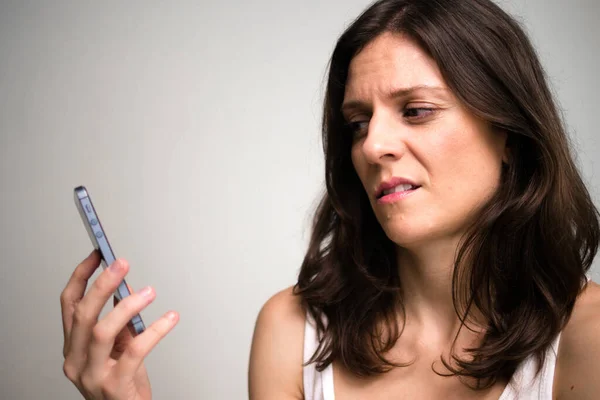 Gesicht einer gestressten Frau sieht beim Telefonieren angewidert aus — Stockfoto