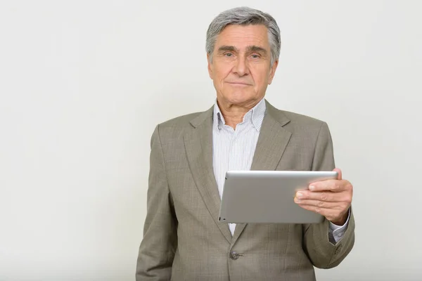 Studio shot of handsome senior businessman against white background