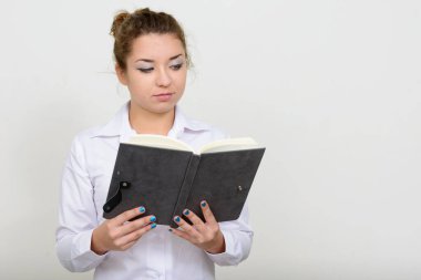 Studio shot of young beautiful businesswoman with brown hair against white background