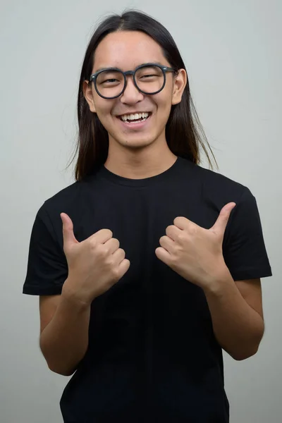 Studioaufnahme Eines Jungen Asiatischen Mannes Mit Langen Haaren Vor Grauem — Stockfoto