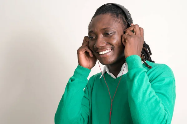 음악을 듣는 레게 머리를 가진 행복 한 젊고 잘생긴 아프리카 남자의 얼굴 — 스톡 사진