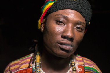 Geceleri dışarıda sigara içen yakışıklı Afrikalı Rastafaryan bir adamın yüzü
