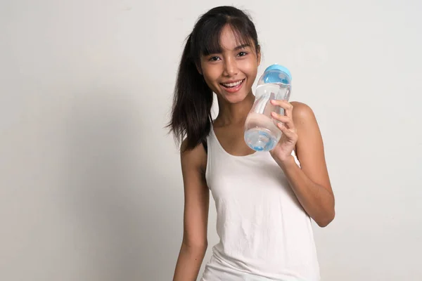 Fericit tineri frumos asiatic adolescenta fata holding apă sticlă — Fotografie, imagine de stoc