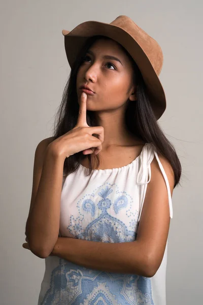 Fiatal gyönyörű ázsiai tinédzser lány, mint turista gondolkodás és felnézett — Stock Fotó