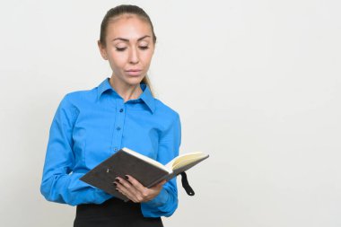 Kahverengi saçlı, kitap okuyan genç iş kadınının portresi.