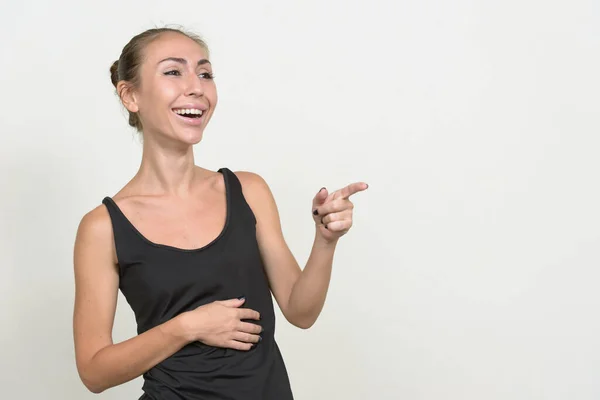 Portret van een gelukkige jonge vrouw die met de vinger wijst en lacht — Stockfoto
