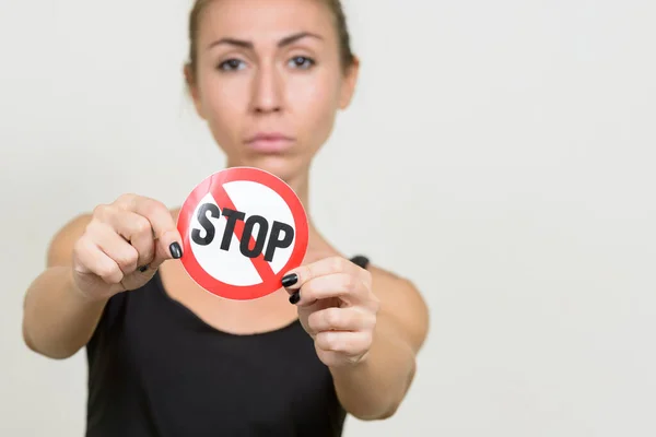 Giovane donna con i capelli castani che mostra segno di stop — Foto Stock